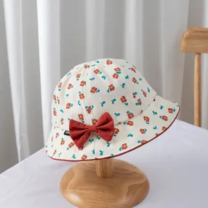 Detail of floral baby sun hat with red bow, mini woven label and fine edge stitching