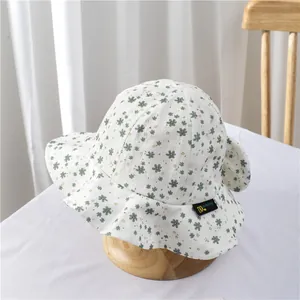 Detail of floral pattern baby sun hat with brand label on soft cotton fabric