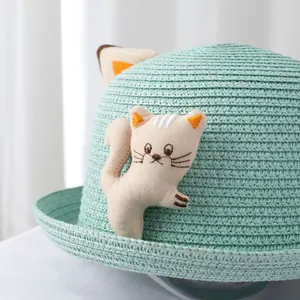 Close-up of light blue straw hat with cute embroidered fabric cat decoration for kids
