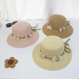 Detailaufnahme der Strohstruktur und Blumenverzierung auf den Sommer-Sonnenhüten