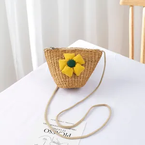 Detailed view of handmade woven straw bag featuring a large yellow fabric flower and zipper