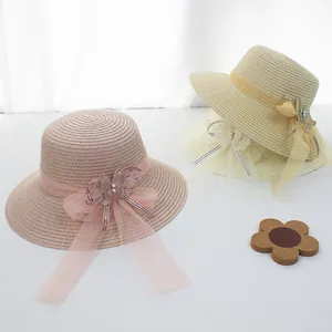 Detail von Strohhüten mit Spitzenblumen, Netzschleifen und Perlen für Sommermode