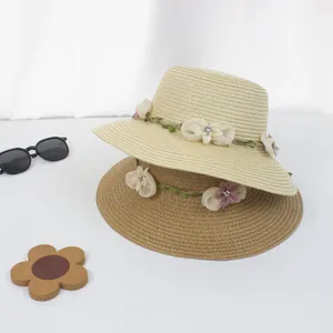 Detailansicht von Strohhüten mit Textilblumen und elegantem Flechtmuster