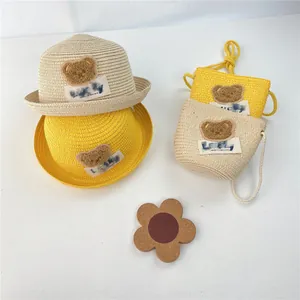 Detail of woven straw hat and mini bag set with plush bear patches and Lucky label