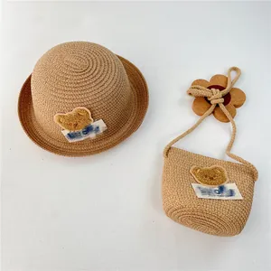 Detail of baby straw sun hat and matching bag with cute teddy bear and gradient label