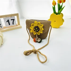 Detail der geflochtenen Kinder-Strohtasche mit großer Sonnenblume und bunten Pompons