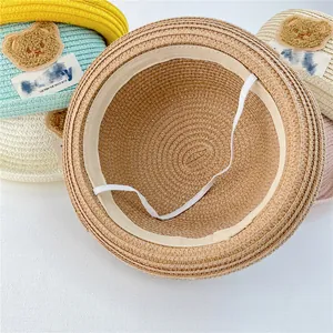 Detailed view of breathable straw sun hats with bear patches and elastic windproof ropes