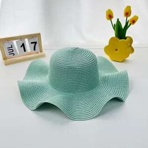 Mint green wide-brim straw sun hat with wavy edges for beach vacations and sun protection