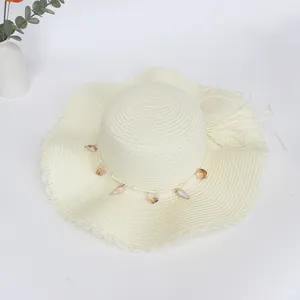 Makro-Detail vom Sommer Strohhut mit Spitzen-Wellenrand und Naturmuschel Dekor