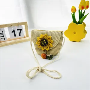 Detail der geflochtenen Stroh-Umhängetasche für Kinder mit Sonnenblume und Pompons
