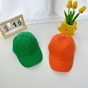 Detail of vibrant green and orange cotton baseball caps with breathable eyelets