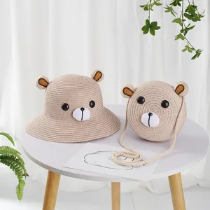 Detail van kinderstrohoed en bijpassende tas met schattig bruin berengezicht