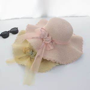 Detail von Sommer-Strohhüten mit gewellter Krempe, Netzschleife und edlen Perlenakzenten