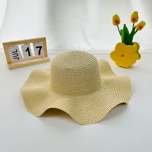 Women's summer straw hat with wide wavy brim and elegant beige woven texture for sun protection