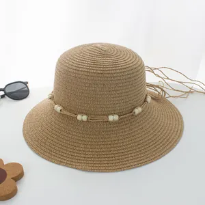 Detailaufnahme vom Strohhut mit weißen Perlen und Bohème-Kordel für den Strandurlaub