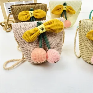 Detail von Kinder-Strohtaschen mit Sonnenblumen-Schleifen und weichen Plüsch-Anhängern