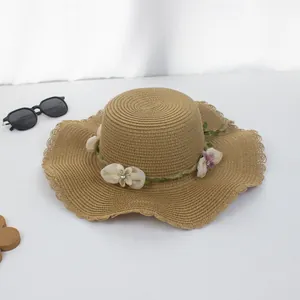 Brauner Strohhut für Damen mit Blumenband und breiter gewellter Krempe für den Sommer