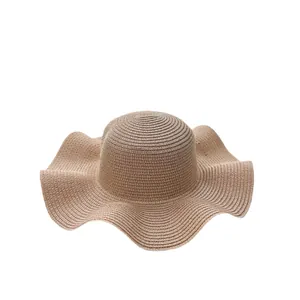 Women's summer straw sun hat with large wavy brim and natural woven texture for beach