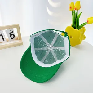 Internal detail of a green acrylic kids baseball cap showing inner lining and strap