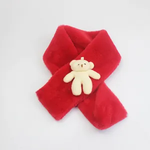 Detail of red faux fur kids scarf featuring a cute plush bear charm for winter warmth