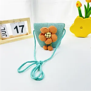 Detailansicht der hellblauen Strohtasche für Kinder mit orangefarbener Blume und Trageriemen