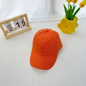 Detailed close-up of bright orange cotton baseball cap with reinforced stitching and eyelets