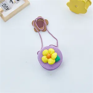 Détail d'un sac rond en paille tressée violette avec une grande fleur jaune pour filles
