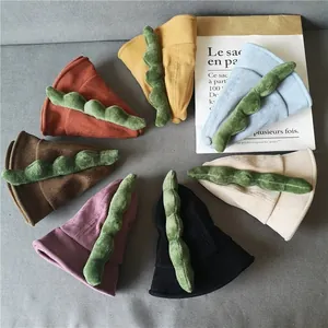 Flat lay of colorful corduroy dinosaur bucket hats with 3D plush dorsal fins for kids