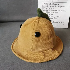 Close-up of yellow corduroy bucket hat with green leaf and button detail for kids