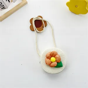 Détail d'un sac rond en paille pour enfants avec une grande fleur en tissu 3D colorée