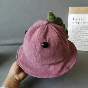 Close-up of purple corduroy kids bucket hat with cute green dinosaur fin details