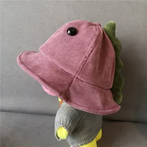 Detail of pink corduroy kids bucket hat featuring plush dinosaur spikes and soft texture