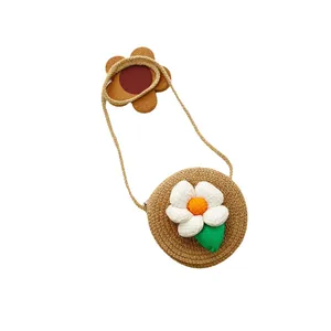 Sac bandoulière rond en paille pour filles avec fleur 3D sur un fond blanc épuré