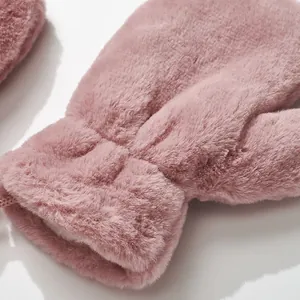 Detailed close-up of pink faux fur mittens with warm plush lining and elastic cuffs