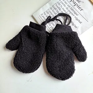 Detailansicht warmer schwarzer Fäustlinge aus Lammfellimitat mit Strickbündchen und Kordel