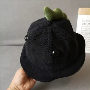 Detailed texture of kids black corduroy sun hat with green plush dinosaur spikes