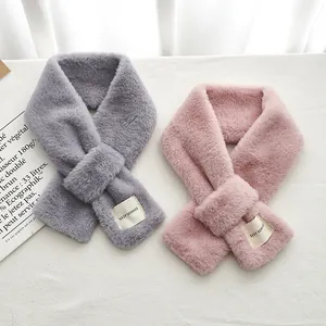 Détail d'écharpes en fausse fourrure pelucheuse avec boucle croisée et étiquette