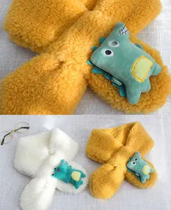Detalle de bufanda de peluche de dinosaurio para niños con diseño de cierre cruzado