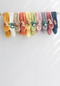 Details von Plüsch-Kinder-Cartoonschals in vielen Farben an einer Holzstange