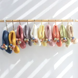 Detailed view of colorful plush fleece scarves with decorative 3D flower accents