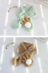 Detailopname van pluche rendiersjaal met bruine geweien en zachte witte pompons