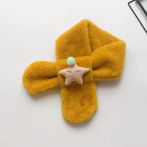 Detail eines gelben Plüsch-Kinderschals mit gesticktem rosa Stern und Bommel