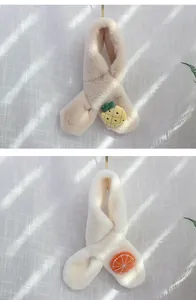 Close-up of plush children's scarves with pineapple and orange fruit 3D patches