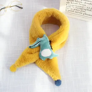 Detail of yellow plush kids scarf with cute green 3D crocodile cartoon ornament