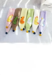 Détails d'écharpes peluches pour enfants avec pompons et motifs de poussins colorés
