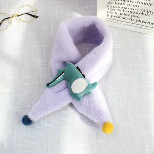 Detail of soft purple plush children's scarf with a green cartoon crocodile and colorful pom-poms