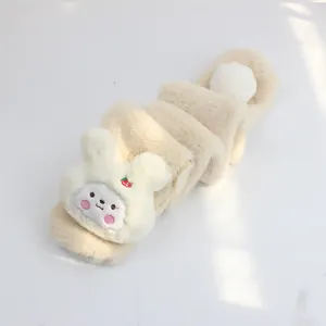 Close-up of soft beige plush kids scarf with cute white rabbit head and strawberry detail