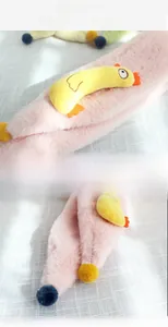Gros plan sur le tissu en peluche rose doux avec détail poussin jaune pour écharpe enfant