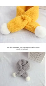 Detail of soft plush winter scarves with fluffy white pom poms in yellow and grey colors