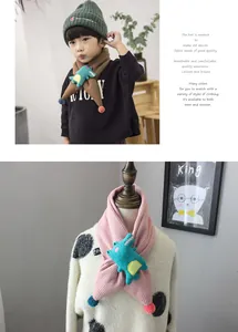 Detail of child scarf showing 3D cartoon crocodile and colorful plush pompom accents
